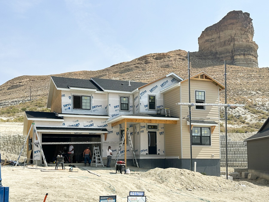 Exterior photo of charming 2-story home with 2-car garage, front porch, white siding and wood accents